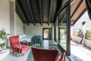 a bedroom with a bed and a balcony with a woman standing on at Agriturismo Olmo in Sondrio