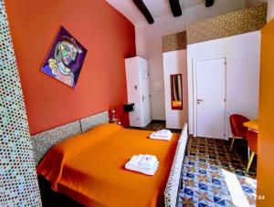 Habitación naranja con cama y mesa en Napoli naif, en Nápoles