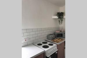 a kitchen with a stove and a microwave at Beautiful 2 bed flat in the heart of Lynton Devon in Lynton