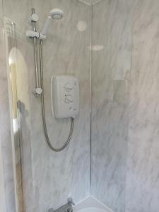 a shower with a glass door next to a sink at Grant Close in Wickford
