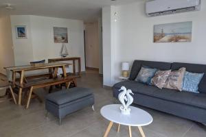 sala de estar con sofá y mesa en El Muelle, Hermoso y cómodo apartamento, en Monterrico