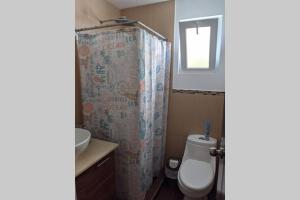 y baño con aseo y cortina de ducha. en El Muelle, Hermoso y cómodo apartamento, en Monterrico