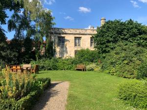 a garden with benches and a building in the background at Minster View Apartment at Talbot Court, York in York