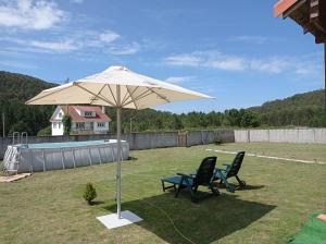 een parasol en twee stoelen in een tuin bij Casa de madera in A Coruña