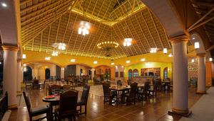 a dining room with tables and chairs in a building at El Corazón Golf & Spa Resort Manzanillo in Manzanillo