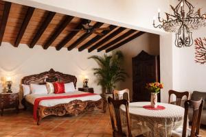 ein Schlafzimmer mit einem Bett, einem Tisch und Stühlen in der Unterkunft BellView Hotel Boutique in Puerto Vallarta