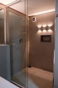 y baño con ducha y puerta de cristal. en Motel Della Montagna (Adult Only) en Bento Gonçalves