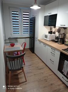 une cuisine avec une petite table et un four micro-ondes dans l'établissement Apartament na parterze, à Stalowa Wola