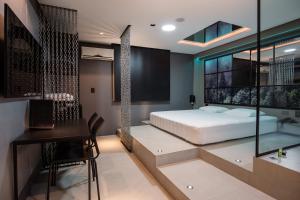 1 dormitorio con cama, escritorio y mesa en Motel Della Montagna (Adult Only), en Bento Gonçalves