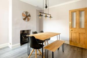 uma sala de jantar com uma mesa de madeira e cadeiras pretas em Entire Property in Hoole, Chester- walking distance to train station & city centre em Chester