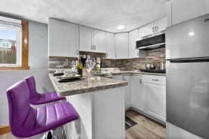 una cocina con una silla púrpura en un mostrador en Suite at House of L, en Chelsea