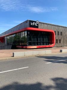 un edificio con un letrero al lado de una carretera en Très beau studio cosy zénith saint etienne en Saint-Étienne