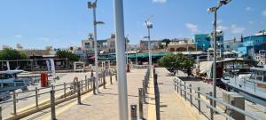 a marina with boats and a pier with buildings at Latchi Area Apartments in Lachi