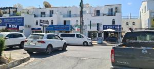 a group of cars parked on a street with buildings at Latchi Area Apartments in Lachi