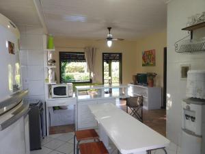 a kitchen with a white counter and a white table at Casa Azul Praia da Pipa Condomínio Pipa Natureza in Pipa