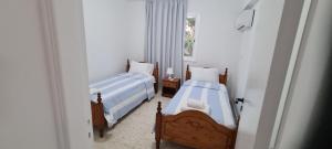two beds in a room with a window at Latchi Area Apartments in Lachi
