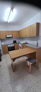 a kitchen with a wooden table and a counter at Latchi Area Apartments in Lachi