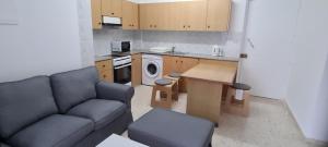 a living room with a couch and a kitchen at Latchi Area Apartments in Lachi