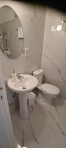 a bathroom with a sink and a toilet and a mirror at Latchi Area Apartments in Lachi