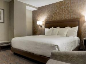 a hotel room with a large bed with white sheets at Kahler Grand Hotel in Rochester