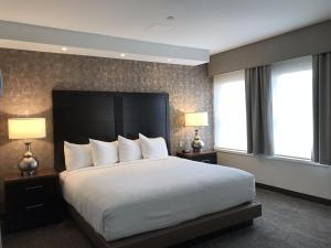 a bedroom with a bed with two lamps and two windows at Kahler Grand Hotel in Rochester