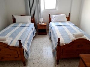 a bedroom with two beds and a window at Latchi Area Apartments in Lachi