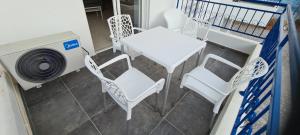 a balcony with a table and chairs and a fan at Latchi Area Apartments in Lachi