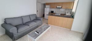 a living room with a couch and a kitchen at Latchi Area Apartments in Lachi