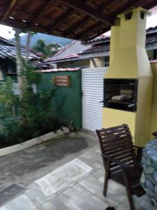 un patio al aire libre con chimenea y silla en Studio Tipo Chale PRAIA SANTA TEREZA, en Ilhabela