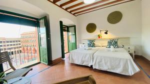a bedroom with two beds and a large window at Hostel Plaza Mayor Corredera in Córdoba