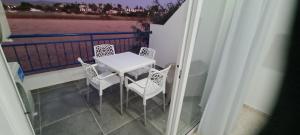 a white table and chairs on a balcony at Latchi Area Apartments in Lachi