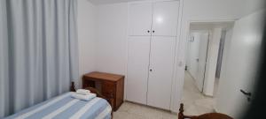 a bedroom with a bed and a dresser and white cabinets at Latchi Area Apartments in Lachi