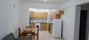 a kitchen with a table and a white refrigerator at Latchi Area Apartments in Lachi