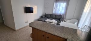 a living room with a couch and a counter top at Latchi Area Apartments in Lachi