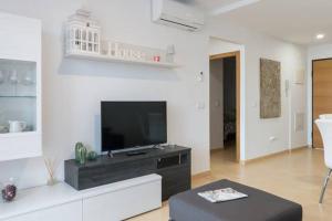 uma sala de estar com uma televisão de ecrã plano na parede em Sol y descanso em Alhama de Múrcia
