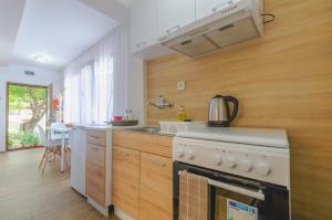 a kitchen with a white stove and a sink at Къща за гости Виктория in Kotel