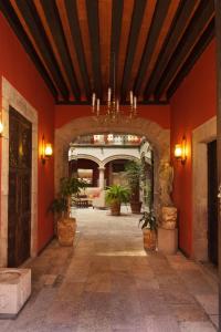 莫雷利亞的住宿－莫雷利亞米西安教堂酒店，一座拥有红色墙壁和盆栽植物的建筑的入口