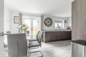 a kitchen and dining room with a table and chairs at Greenfield's - New Modern 3 Bedroom Home - Johnstonen Close, Bracknell in Bracknell