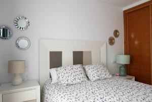 um quarto com uma cama e 2 candeeiros e espelhos em Sol y descanso em Alhama de Múrcia