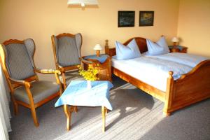 a bedroom with two beds and two chairs and a table at Appartementhaus Panny in Bad Füssing