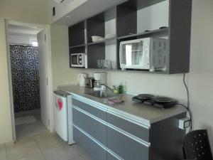 a kitchen with a sink and a microwave at Alugar in Valeria del Mar