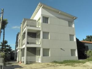 un edificio de apartamentos blanco con balcones. en Alugar en Valeria del Mar