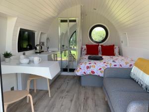 a room with a bed and a table and a couch at Laurel Farm Glamping in Mark