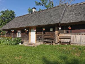 an old cabin with a white door and a roof at Ojcowizna na Kresach in Jurowlany