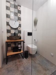 a bathroom with a toilet and a glass shower at Ojcowizna na Kresach in Jurowlany