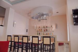 a dining room with a bar and chairs at Glyfada Beach Hotel in Glyfada