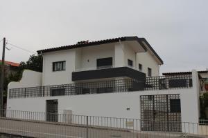 een wit huis met een zwart balkon bij Casa dos Amigos - Arouca in Arouca