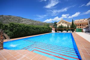 a swimming pool with blue water in a resort at Apartamentos Rurales Campillo in Arroyo Frio