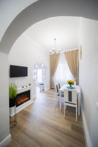un soggiorno bianco con tavolo e camino di BlueSky Ultra-Central Premium Apartment a Oradea