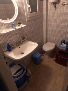 La salle de bains est pourvue d'un lavabo et de toilettes. dans l'établissement Relaxation and Vacation with all the Comforts, à Athènes